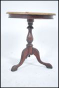 A Victorian mahogany tripod wine table raised on a splayed leg base, turned column with circular top