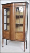An Edwardian mahogany inlaid display cabinet of large form being raised on splayed legs with twin