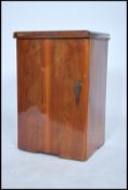 A 1930's Art Deco walnut sewing machine cabinet having flip over top with swivel up action and inset