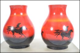 A pair of mid 20th century Sylvac flambe vases in the wild horses pattern of bulbous form being
