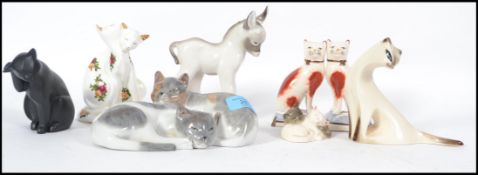 A group of ceramic cats to include a Dresden cat group, Coalport black cat sprucing up, Jersey