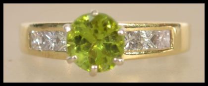 A 14ct yellow gold ladies ring being set with a central peridot of approx 1.5ct's and flanked by