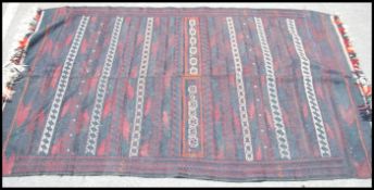 An Afghan / Persian Balouch Kilim rug having dark central ground with central runs of spiral