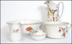An early 20th century ceramic wash set decorated with transfer printed birds of paradise and stamped