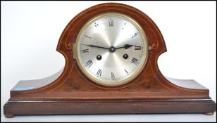 An Edwardian mahogany inlaid napoleons hat mantel clock having silvered dial with roman numeral