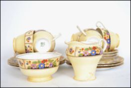 An Aynsley 6 person art deco tea service in a chintzy pattern on a cream background consisting of
