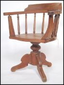 An unusual hardwood office Captain's swivel chair being raised on splayed leg base with swivel