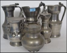 A collection of old pewter to mainly include lidder ewer jugs of varying large sizes. One marked for