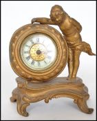 A late 19th century gilt cast metal desk clock of a cherub raised on socle base fitted with a
