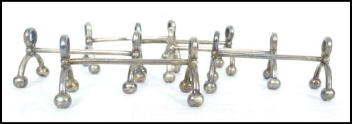 A set of silver plated knife rests having bow legs with ball feet with hoops to top each being