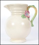 A vintage 20th century Art Deco Clarice Cliff for Newport  tall pottery jug with floral handle,