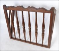 An early 20th century oak wall mounted magazine rack having spindle gallery railed front and