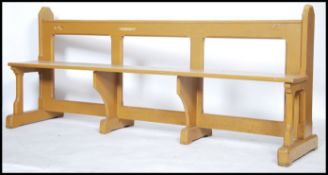 An early 20th century painted  pitch pine church pew raised on stepped end supports