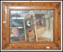 A 19th century walnut sea weed marquetry inlaid cushion framed wall mirror having central mirror