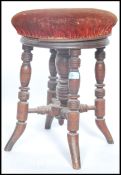 A Victorian aesthetic movement mahogany circular revolving piano stool. The pad seat with swivel