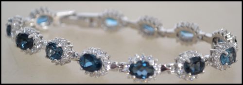A ladies contemporary silver and blue topaz adorned bracelet with clasp complete in the presentation
