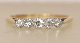 An 18ct gold and diamond ring set with five diamonds in a prong setting. Marked 18ct & Plat, tests