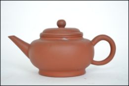 A Chinese yi-xing teapot ( tea pot ) dating to the 20th century being finely potted from terracotta.