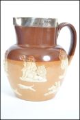 A Doulton Lambeth stone ware salt glazed harvest jug having a silver collar with notation for