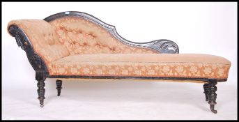 A late Victorian ebonised mahogany chaise longue day bed being raised on turned legs with castors.