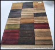 A retro 20th century deep pile woollen rug having an alternating geometric pattern with tassel ends.