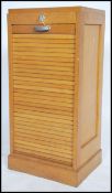 A 1950's retro industrial beech wood tambour fronted filing cabinet raised on a plinth base with