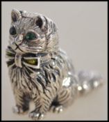 An unusual cast sterling silver figure of a cat adorned with emerald eyes ( see illustrations )