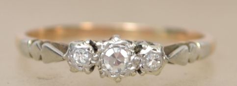 An early 20th century 18ct gold three stone diamond ring set with three old cut diamonds in an