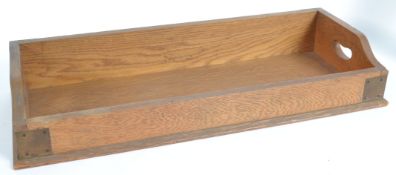 A Victorian oak library tray with bracket work joints and dovetailing having gallery sides with