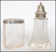 A hallmarked silver topped glass dressing table pot along with a cut glass sugar sifter with a