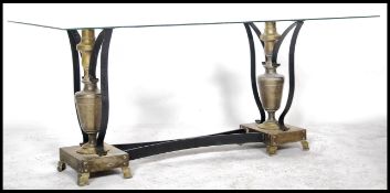 A mid century brass and strap metal rococo glass coffee table. The base with twin urns and