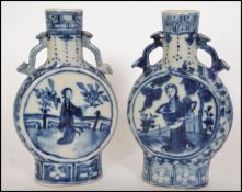 A pair of 19th century Chinese Kangxi blue and white twin handled moon flasks. Each with