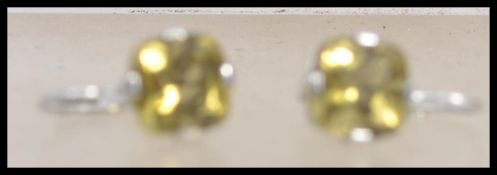 A pair of 9ct white gold drop earrings with yellow stone. Weight 2.4g.