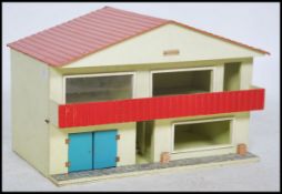 A vintage 1970's dolls house of colourful form. The house in the form of a chalet with red roof (