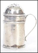 A 19th century silver hallmarked Victorian pepper shaker / pot with handle to side. Hallmarked for