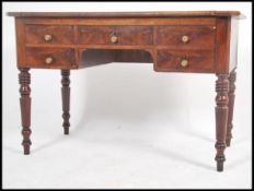 A Victorian mahogany large writing table desk raised on turned legs with a series of drawers