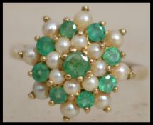 A hallmarked 9ct gold cluster ring set with emeral