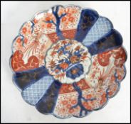 A 19th century Chinese Imari pattern wall plate charger in red, white and blue with central design
