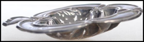 A silver hallmarked Art Nouveau tea strainer in the form of a leaf with banded scroll work borders