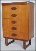 A retro teak wood straight five chest of drawers having an upright pedestal of drawers with shaped