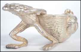 A substantial silver plated table salt in the form of a frog pulling a shell