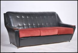 A retro 1970's two tone black and red vinyl upholstered sofa settee having flashwork walnut /