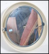 A large retro circular wall hanging mirror hinged