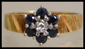 An 18ct gold sapphire and diamond cluster ring wit