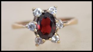 A hallmarked 9ct gold ring set with a red stone su