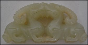 An Oriental jade carving depicting two horned drag