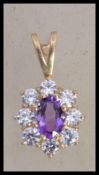 A hallmarked 9ct gold cluster pendant set with a c