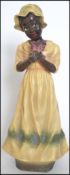 A 20th century resin figurine of a Negro girl in a