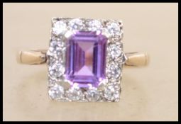 A hallmarked 9ct gold cluster ring with central em