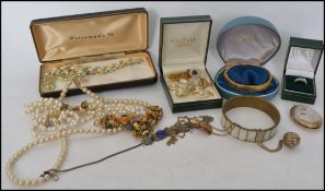 A box of costume jewellery to include rings, watch